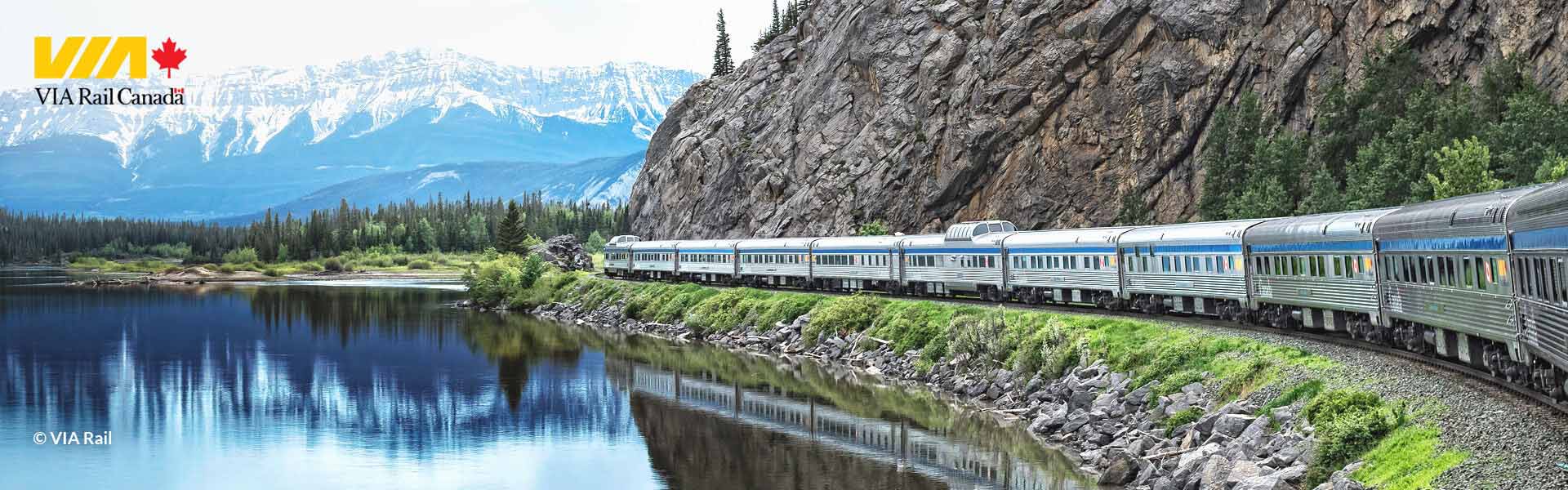 Train along the edge of lake and mountain